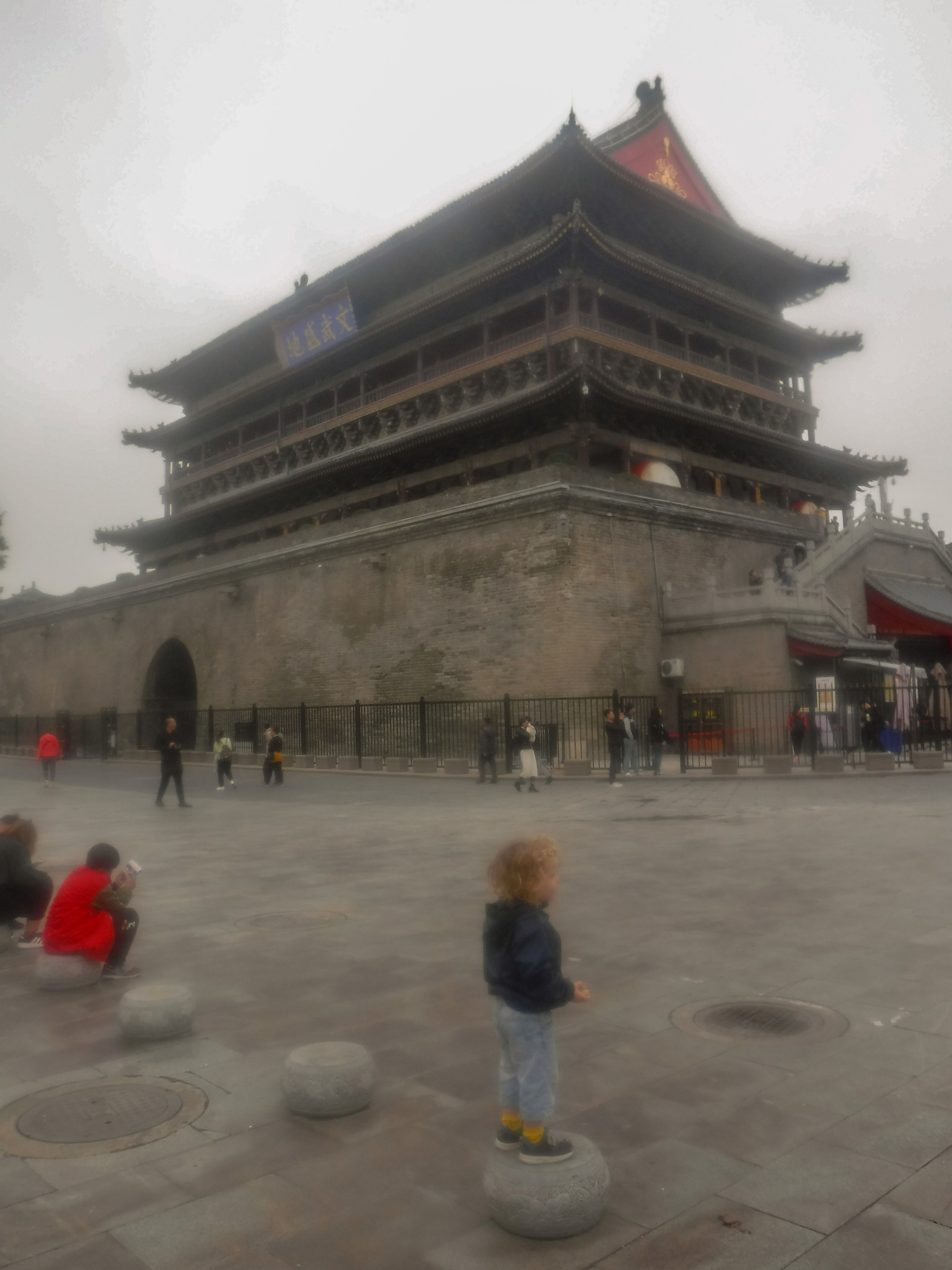 child stood in front of drum tower in Xian in China