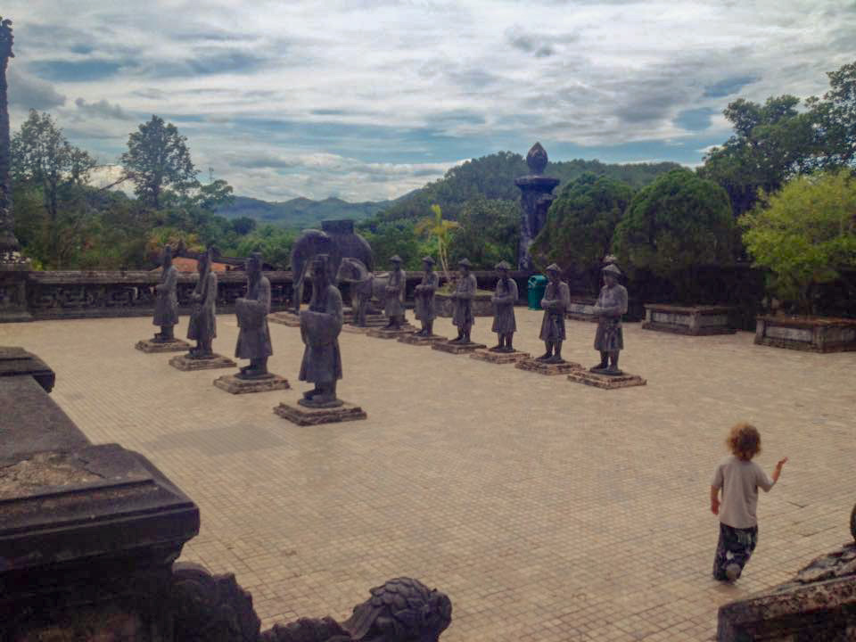Child with statues at Khai Ding Tomb in Vietnam