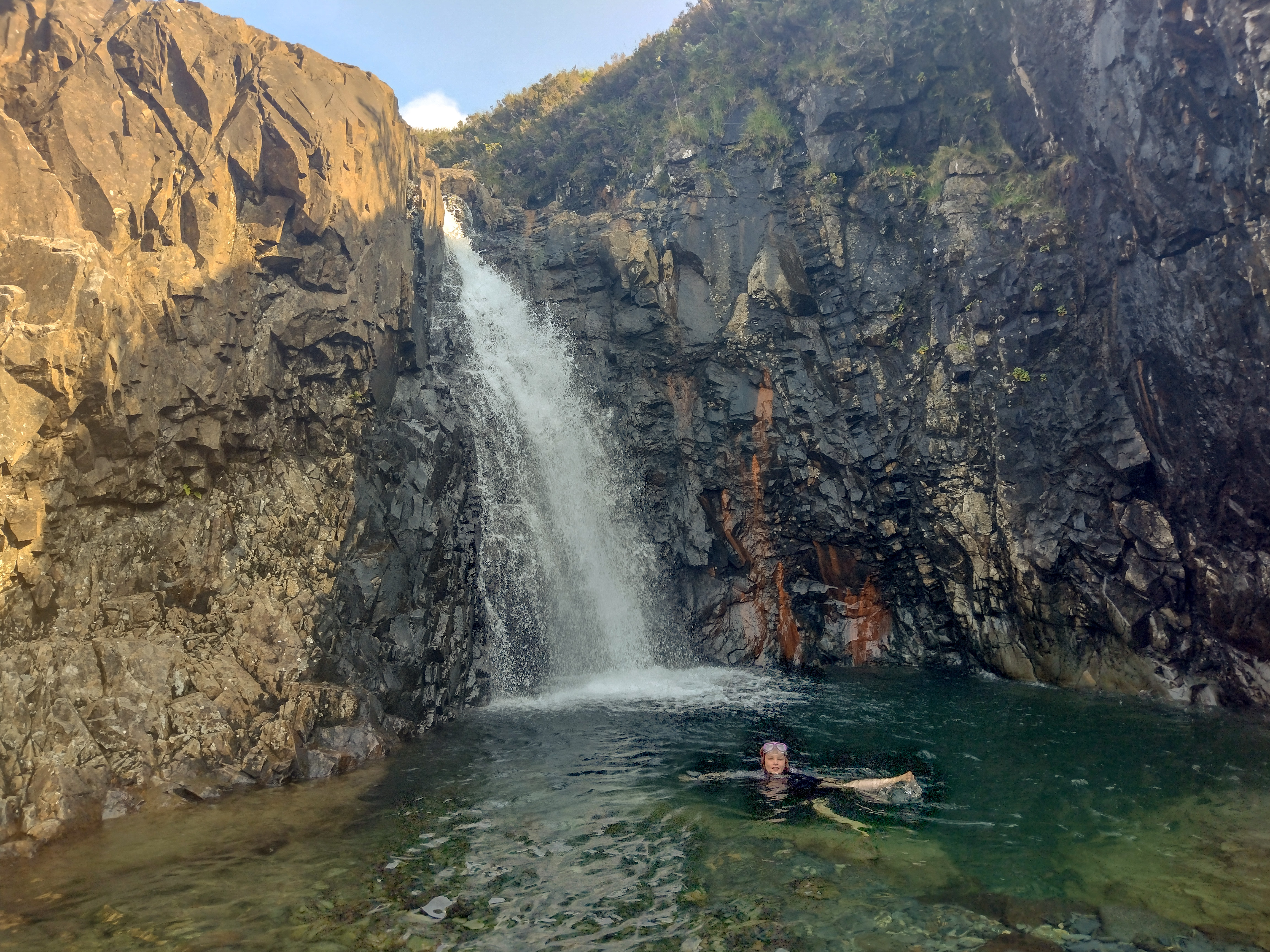 child swimming in fairy pools on Isle of Skye in Scotland