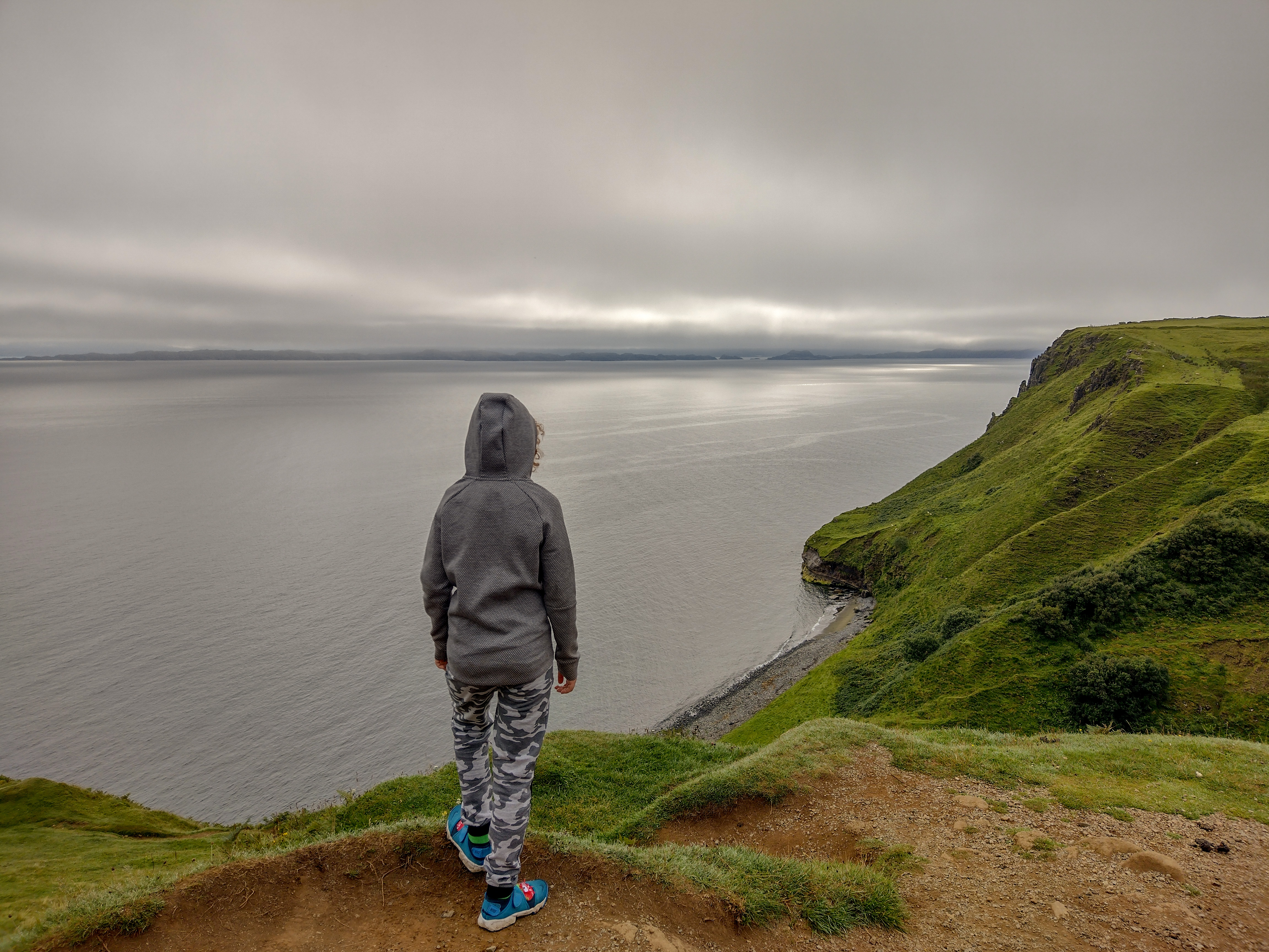 child looking over Isle of Skye coast near Lealt Falls in Scotland