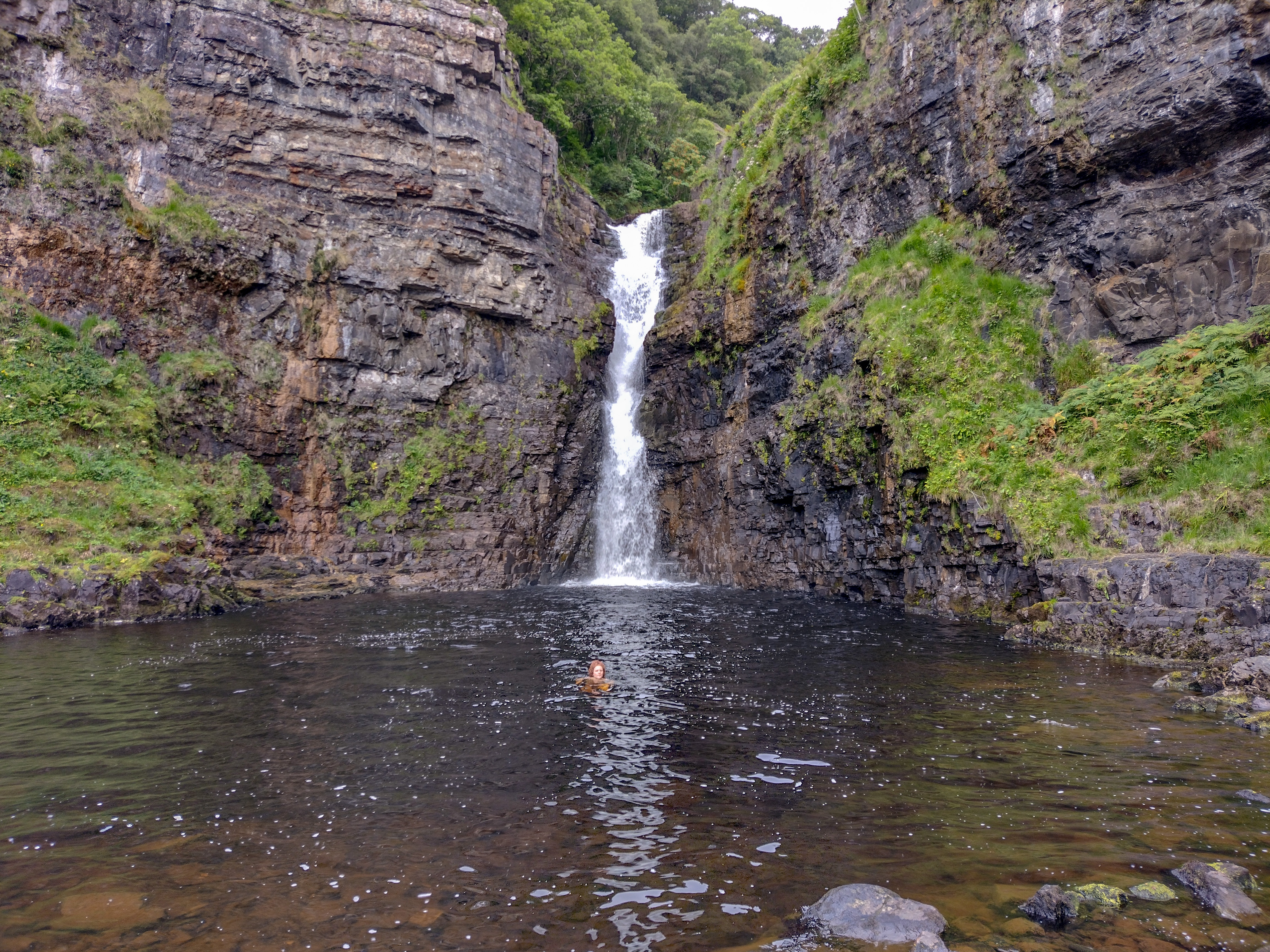 child swimming in Lealt Falls in Scotland