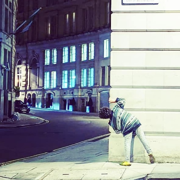 Child looking round street corner in London