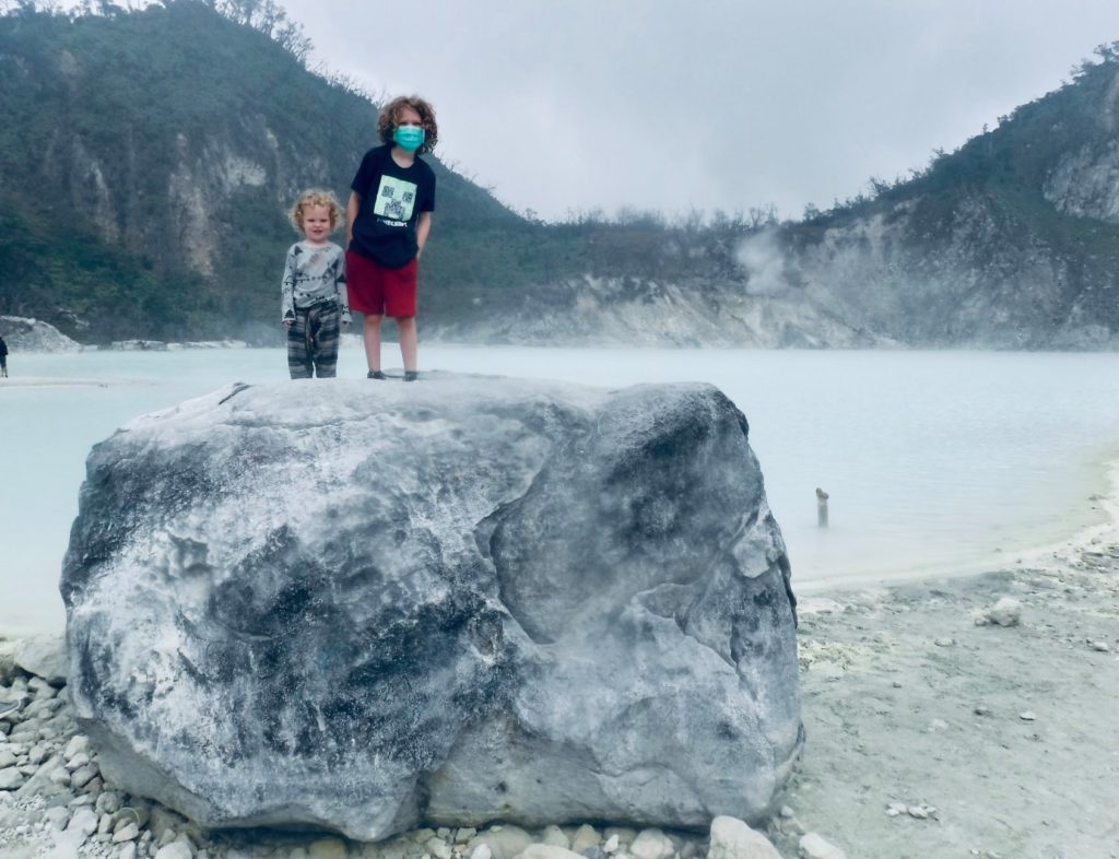 Two Children stood on Rock at White Crater in Bandung, Indonesia