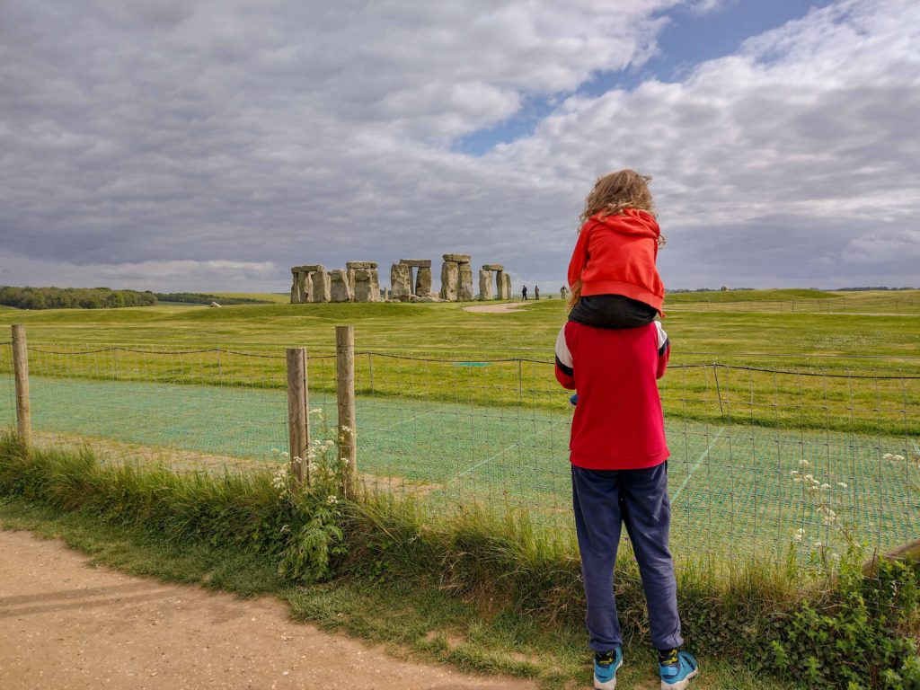 a child with another child on soldiers looking at Stonehenge