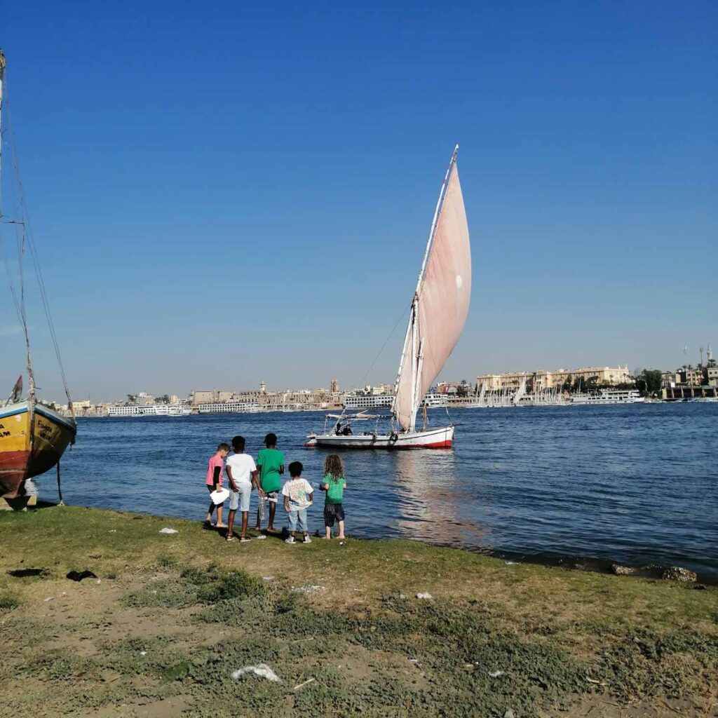 Child looking at Felucca Boat in Luxor Egypt