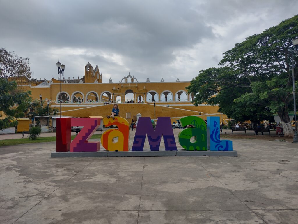 Child sat on Izamal sign in Mexico